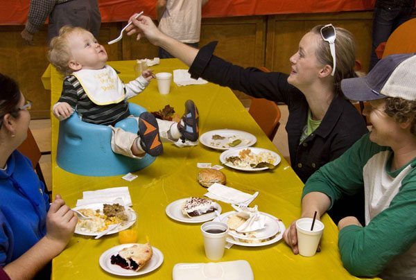 Riley Lawreniuk of Dalmeny, Sask., had a front row seat to his first fowl supper held Oct. 25 in Langham, Sask. Riley’s mother, Stephanie, feeds him turkey alongside father, Jason. At left is Meghan Merkowsky of Dalmeny. A new record was set with more than 800 people attending the supper. (WP photo by William DeKay)