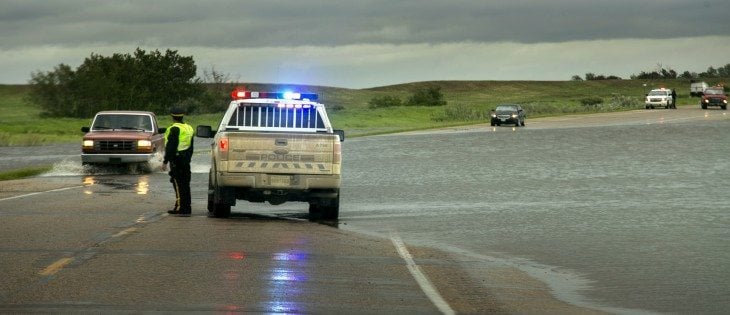 RCMP direct traffic on Hwy 16, 1 Km east of Elfros, Sask., after flash flooding covered the highway. Many towns in eastern Saskatchewan and western Manitoba declared states of emergency as rain continued to fall in the region June 30. | Robin Booker photo