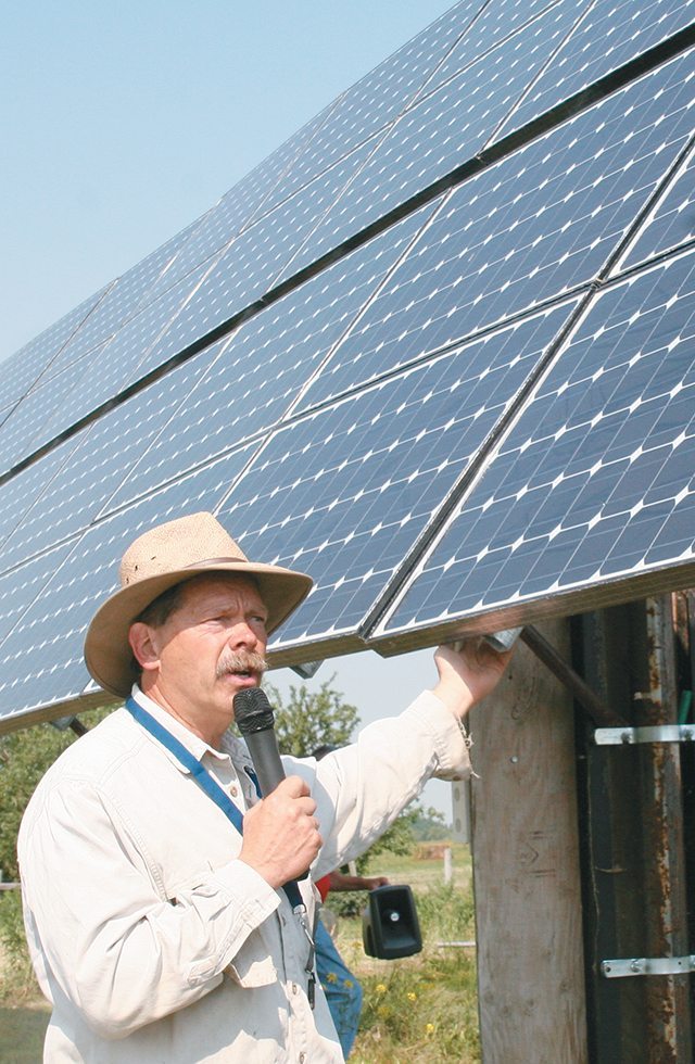 Vern Bretin explains how his large solar powered unit works on his farm near Calgary where he and his wife, Patty, run a major greenhouse operation. | Barbara Duckworth photo.