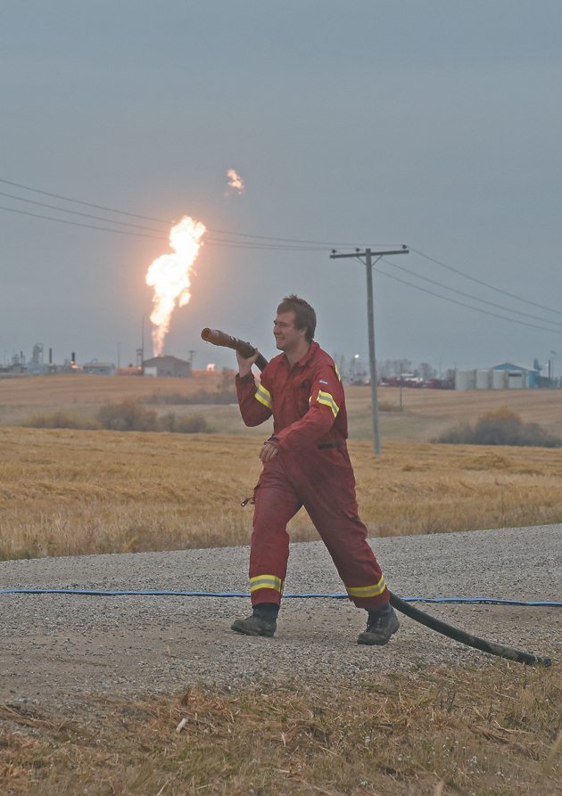 A firefighter with Emergency Management and Fire Safety in Prince Albert, Sask., rolls up a hose after replenishing the water tank on a truck. | William DeKay photo