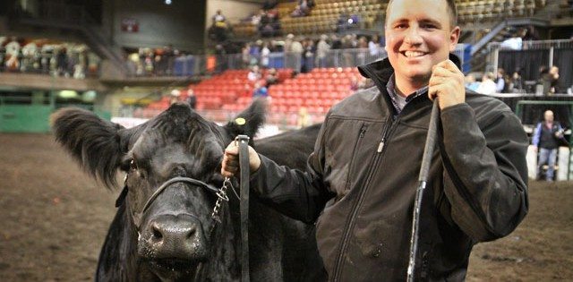 Garth Rancier of Killam wins the Supreme Champion Female at Farmfair with a simmental cow from a winning family. The cow's family has won three trucks. The cow and calf are co-owned with Westman Land and Cattle.