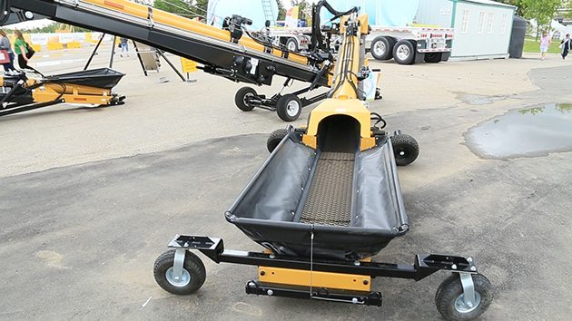 The optional swing out pivots around the front to unload belly-dump trailers, trucks and grain carts. It is operated at the hydraulic controls at the front of the machine. | Robin Booker photo.