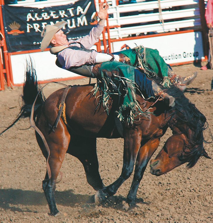 Linden Woods of Maple Creek, Sask., rides Good Times in the bareback bronc event at the Maple Creek Rodeo. | Christalee Froese photo