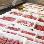 Various cuts of raw red meat are on display in a meat shop.
