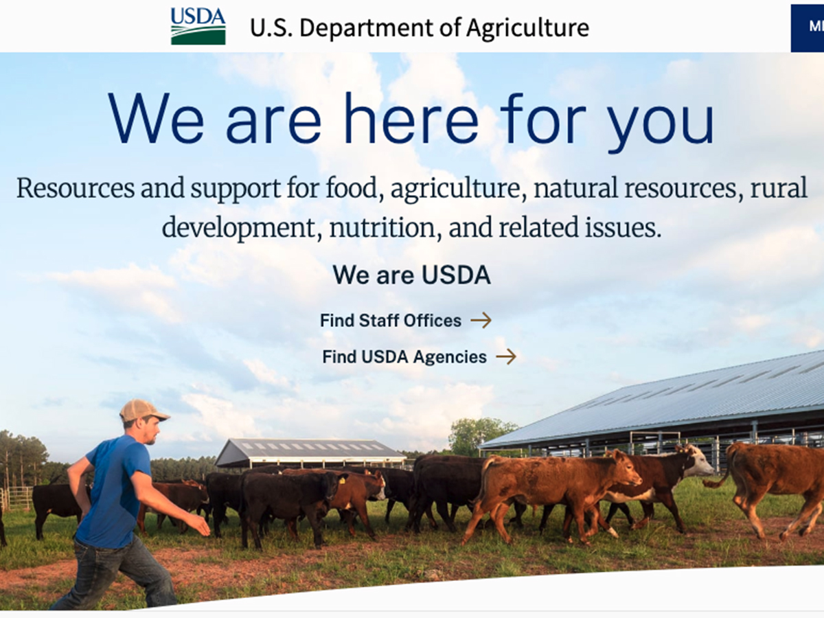 Screencap of the homepage of the USDA with an image of a farmer walking through a pen with cattle in it.