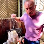 A screencap from x.com of Robert F. Kenedy Jr. about to lower a raw turkey into a vat of boiling beef tallow.