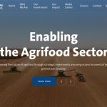 Screencap of the homepage of the Saudi Agricultural and Livestock Investment Company (SALIC) showing a drone image of two combines and a tractor pulling a grain cart in a wheat field.