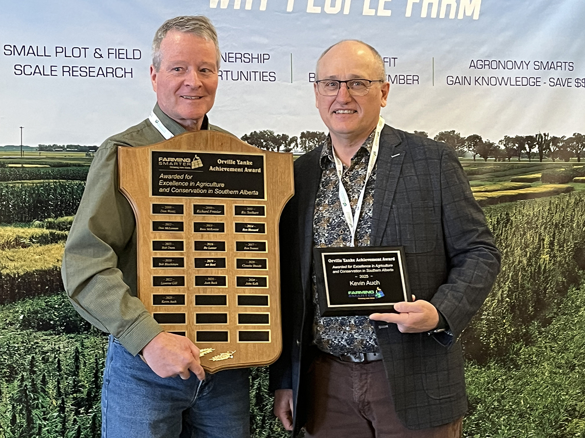 Rob Dunn, left, presents Kevin Auch with the 2025 Orville Yanke Achievement Award at the Farming Smarter Conference and Trade Show in Lethbridge.