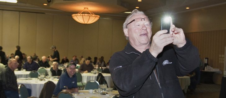 Berny Wiens of Hershel, Sask., uses his smart phone to photograph the screen while Patty Rosher from the Canadian Wheat Board talks about Weatherfarm Jan. 13 during Crop Production Week in Saskatoon.  |  William DeKay photo