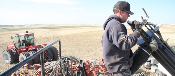 Nathan Weber helps fill a cart with fertilizer as he and other neighbours of Eric and Wade Donovan, and Denny Loree, who were killed in a May 12 plane crash, prepare to seed 600 acres of canola on Donovan’s land near Mossleigh, Alta.  |  Barb Glen photo