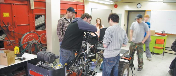 Students with the University of Manitoba Association of Tiny Tractors put the finishing touches on their 31 horsepower pulling machine.  |  University of Manitoba photo