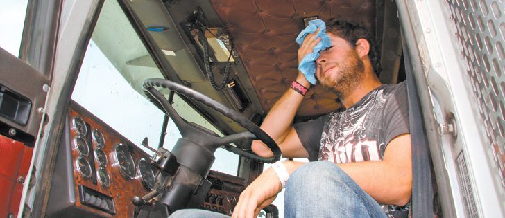 Ryan Williamson wipes sweat from his brow in 30 C heat as he waits for combines to fill the super B grain hauler he is driving on behalf of Groenenboom Farms of Coalhurst, Alta. That farm and many others bought some of the barley that will come off this field, and all donated the purchase price to the Canadian Foodgrains Bank.  |  Barb Glen photo