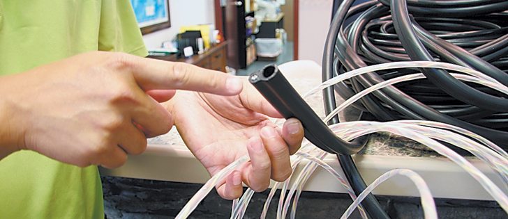 This cable system contains sensors every three feet to measure heat and humidity in grain bins. The plastic wires holding the sensors are inserted in the heavier cable and using wireless technology can alert farmers within minutes if conditions change.  |  Barbara Duckworth photo