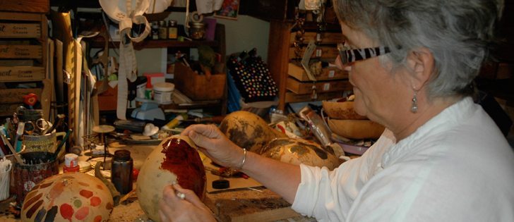Boquist puts the first coat of paint on a gourd that will eventually become art.  |  Shannon Moneo photo