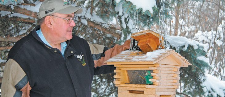 Lorne Scott, avid conservationist and farmer, checks one of the many bird feeders in his farmyard near Indian Head, Sask.  |  Karen Briere photo