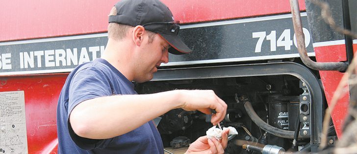 Lane Stockbrugger checks fluid levels on his tractor. | Karen Morrison photo