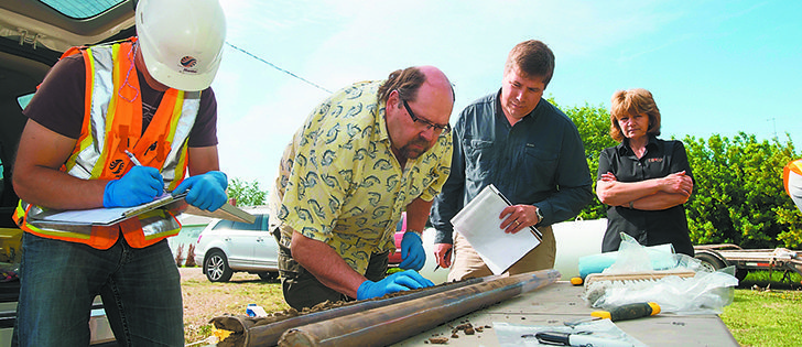 University of Saskatchewan soil scientist Richard Farrell, centre left, and Trevor Carlson, environmental affairs director at Federated Co-operatives Limited, centre right, review soil samples taken at a former Co-op petroleum site at Colonsay, Sask.  |  Federated Co-operatives ltd Photo