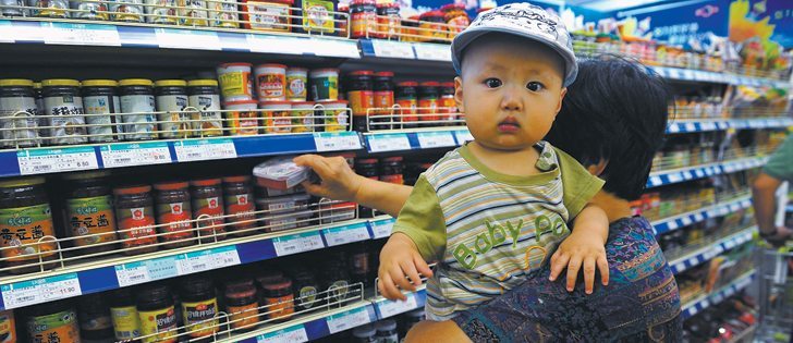 A customer holds a child while shopping at a supermarket in Shenyang in Liaoning province. The Chinese government is encouraging consumers to spend more.  | Reuters photo