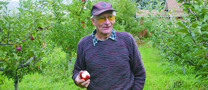 David Evans bites into an Okana apple in his orchard in British Columbia’s Okanagan Valley.  |  Susan McIver photo
