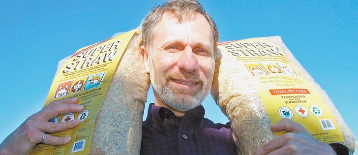 Eugene Gala, part owner of Biovalco, a Manitoba company specializing in biomass heating systems and biomass processing, holds up bags of SuperStraw, an animal bedding product that absorbs more water than regular straw. Gala and his business partner, Stephane Gauthier, produce SuperStraw at their processing plant in La Broquerie, Man.  |  Robert Arnason photo