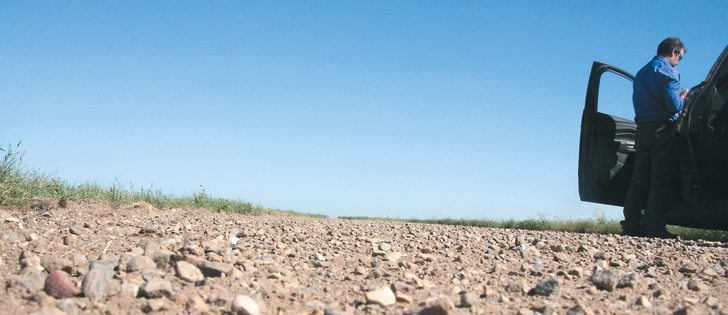 Justin Daniels of the CWB makes notes at a stop on a gravel road near Foremost, Alta. during the prairie-wide crop tour last week.  |  Barb Glen photo