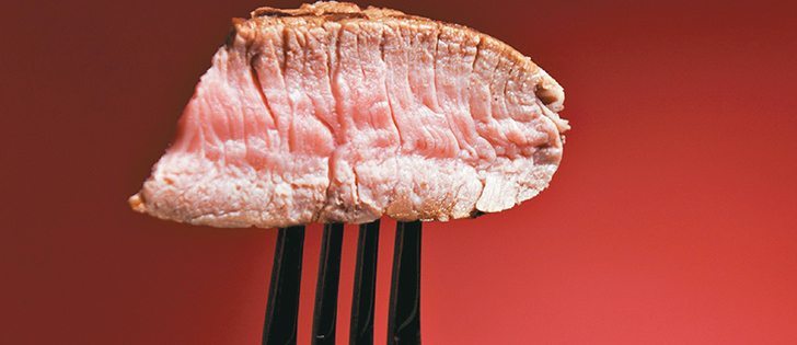 File photo (date last used March 20, 2014)
Piece of a grilled steak on a fork isolated on red