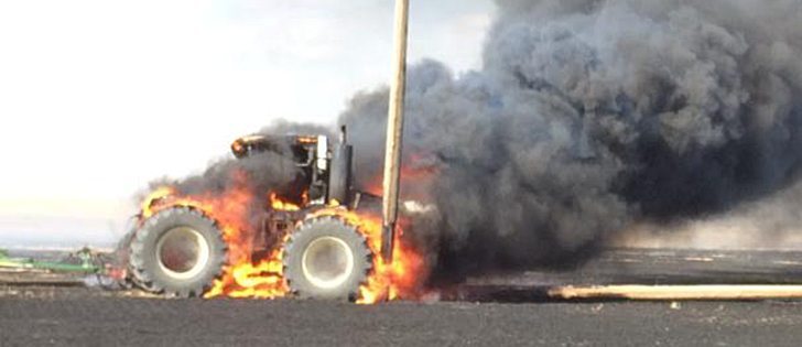 This tractor was destroyed by fire after running into a power pole near Outlook, Saskatchewan on May 9, 2015. | Jim Wickett,@jw4830 / Twitter photo