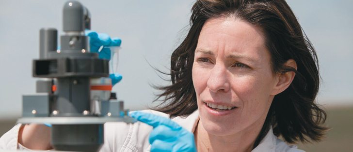Melanie Kalischuk, an instructor in the environmental sciences program at Lethbridge College, installs a Burkard trap at an Alberta potato farm to monitor the levels of Phytophthora infestans.  |  Lethbridge College Photo
