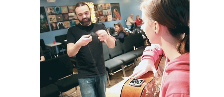 Richard Groulx assists his guitar student, Ellie Noble, as she gets set to perform for the first time at the Jam Space in Lemberg, Sask. | Christalee Froese photo