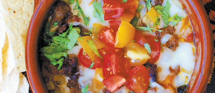 Queso fundido con chorizo, above, bacon-wrapped prawns, and grilled grape leaf-wrapped goat cheese are light appetizers to serve at a summer get together.  |  Sarah Galvin photo