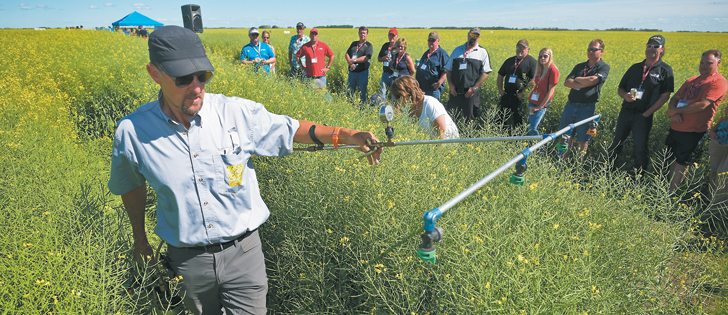 Running at eight m.p.h. between stakes, Tom Wolf illustrates sprayer nozzle penetration during a Canola Harvest Innovation Demo Day hosted by BASF July 27 at Stenen, Sask. |  William DeKay photo