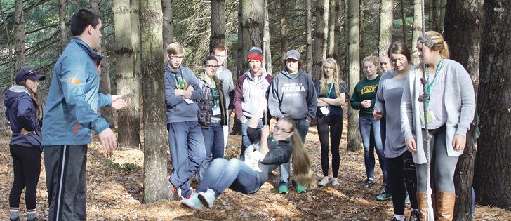 Magdalena Melnychuk, above, of the Balmoral 4-H Club in Manitoba pretends to have to swing across water to survive and, left, navigate a crowded log in exercises to learn how to work together.  |  Karen Morrison photo