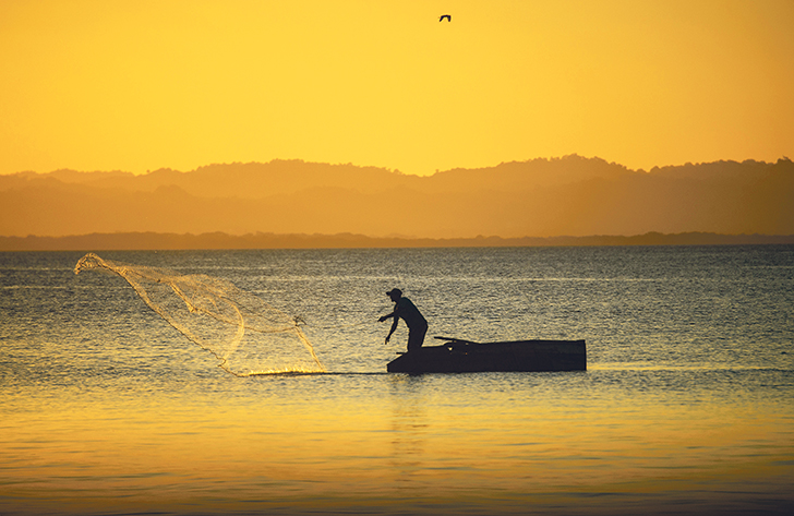 A fisherman casts his net early in the morning at Lake Nicaragua. | Arlene & Robin Karpan photo