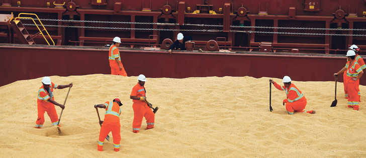 Employees level grain on the cargo ship Kypros Land, which was loading soybeans to China at Tiplam terminal in Santos, Brazil, March 13. | REUTERS/Paulo Whitaker photo