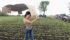 Cardboard doubles as an umbrella as Erin Cote hurries back to the truck at test plots at the Ag In Motion site near Saskatoon June 9. Unlike south of the border, recent rain helped spring wheat across the Prairies. | William DeKay photo