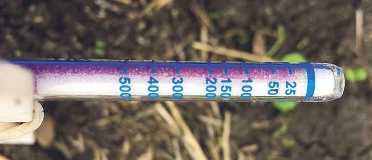 Dositubes, used to measure nitrogen volatilization losses, were placed under boxes with holes drilled in them on a recently seeded field shallow-banded with urea. The tubes contain purple packing material containing sulfuric acid that turns yellow when it reacts with the gas.  | Agritruth Research photo
