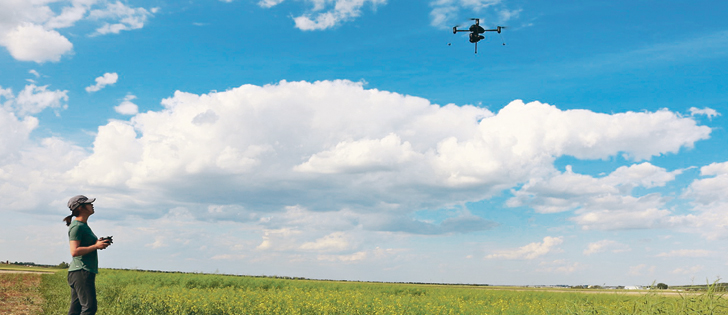 Ti Zhang, a PhD student from the University of Saskatchewan, flies an unmanned aerial vehicle over canola research plots east of Saskatoon to study the effect of nitrogen fertility on flowering, leaf area, pod, and crop yield using drone-based phenomics.  |  University of Saskatchewan photo
