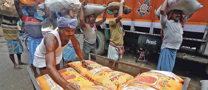 A labourer marks sacks filled with pulses before loading them into a truck as others wait in a queue to load at a wholesale market in Kolkata, India, May 16, 2016.  |   REUTERS/Rupak De Chowdhuri photo