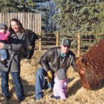 Ivy, left, Amber, Trevor and Isely Burks pose in the bull pen at their Twisted T Gelbvieh farm near Parry, Sask. | Karen Briere photo