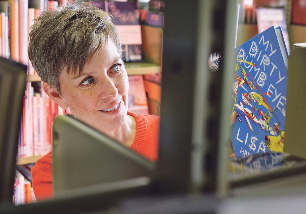 Deb Cryderman, director of the Camrose library, puts a book back on to a shelf.  |  Jeremy Simes photo