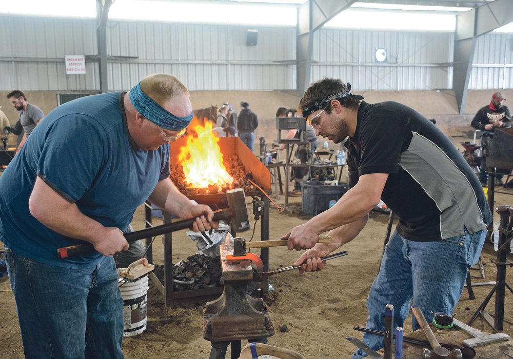 Jason Wrubleski and Greg Toronchuk work together to forge a regular horseshoe and a therapeutic horseshoe in the two-man, 45-minute event. In this instance, Wrubleski is the main man and Toronchuk his helper. They later reversed their roles for the second two-man event.  | Les Dunford photo