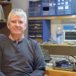 Creator of Ag Open GPS, Brian Tischler, sits in the electronics lab he built in his basement. He uses the lab to develop projects or fix farm electronics. | Robin Booker photo