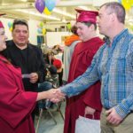 Chief Lance Roulette of Sandy Bay First Nations and Brady Racette watch Jeremy Janzen, senior director of human resources for Hylife Foods, congratulate Melanie Richard after the graduation ceremony at the band’s meat-cutting school. | Sandy Black photo