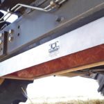 The drop pan is held up tight against the combine with electromagnets. Because there is no wiring or bolts, it can be moved from one combine to another in a matter of seconds. A radio remote control lets the operator drop the pan while driving at the normal speed with all adjustments in their normal position. | Marcel Kringe photo