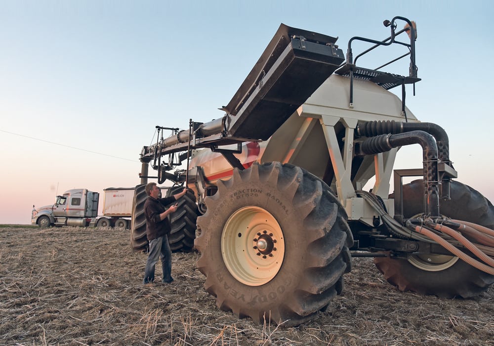 Gary Hennings moves the auger back into place as he seeds hard red spring wheat south of Unity, Sask., May 25.  |  William DeKay photo