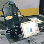 The CropScan 3000H captures clean grain coming up the combine’s clean grain elevator, scans it with near infrared technology, analyzes the readings, and then sends the information to a touch screen PC in the combine’s cab. | Robin Booker photo