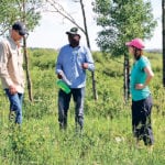 Akim Omokanye, centre, speaks with producers about his research during a field tour near Wanham, Alta. | Jeremy Simes photo