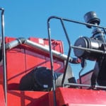 Many combine fires can be prevented by keeping dust off hot turbo and exhaust surfaces, which is what this kit from South Dakota accomplishes with a fan funnelling filtered air into a shroud surrounding the exhaust system. | Daniel Humburg photo