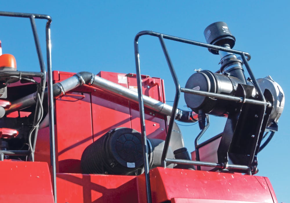 Many combine fires can be prevented by keeping dust off hot turbo and exhaust surfaces, which is what this kit from South Dakota accomplishes with a fan funnelling filtered air into a shroud surrounding the exhaust system.  |  Daniel Humburg photo