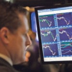 Looking back at trying times. A trader works near a monitor displaying stock prices on the main trading floor of the New York Stock Exchange early in a trading session, Dec. 8, 2008, that was hoped to prevent a major recession. | REUTERS/Mike Segar photo